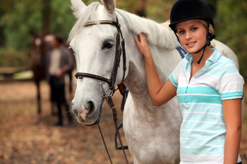 Blond teenager next to horse