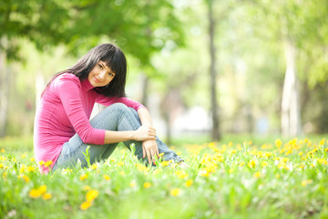 Cute woman in the park with dandelions