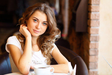 Young pretty woman sitting in restaurant