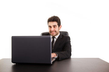 Young business man with laptop at office desk, isolated in white