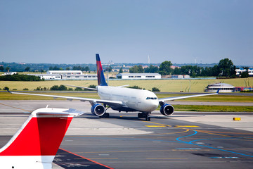 Large white commercial airplane taxiing from runway