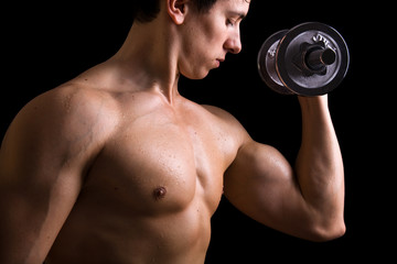 Fototapeta na wymiar powerful muscular man lifting weights on black background