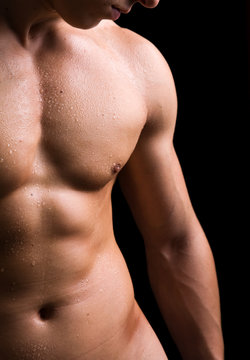 torso of young muscular man, isolated on black background