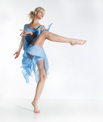 Wellness. Beautiful sexy slim woman dancing in cyan dress