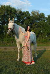 Girl with horse taking a walk in summer evening