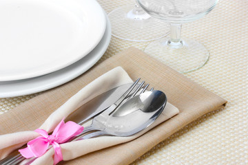 Table setting with fork, spoon, knife, plates, and napkin