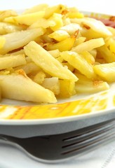 Fried potato in a plate and fork