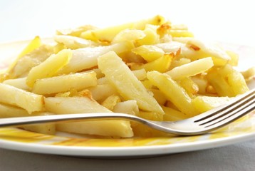 Fried potato in a plate and fork