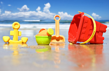 Children's beach toys at the beach  - focus on watering can