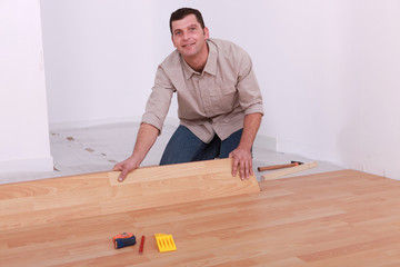 Man installing laminate flooring