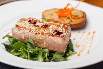 Fried tuna steak and potatoes on the plate