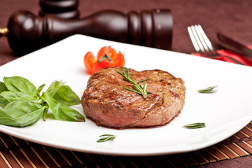 Grilled steak on a white plate