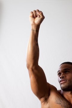 strong man toopless, arm raised in a fist