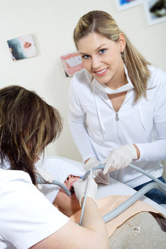 Zahnarzt Assistentin lächelt freundlich bei Behandlung