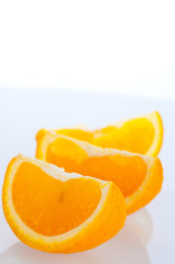 Fresh segments of an orange on a white background