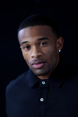 black man in black shirt , with serious look