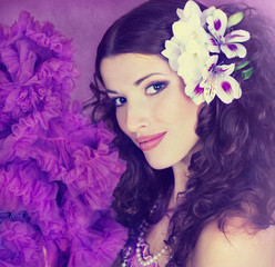 Naklejka premium Portrait of the young, beautiful brunette in a lilac dress and w