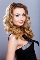 Young woman in black dress with curly hair