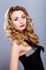 Naklejka premium Young woman in black dress with curly hair