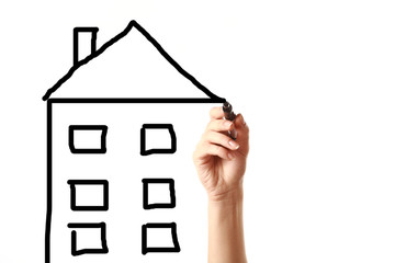 Female hand drawing a house with black marker