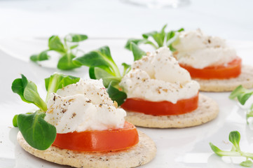 Tartine di formaggio, pomodoro e erbette, close-up