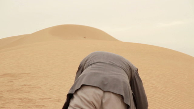 Exhausted businessman crawling in the desert