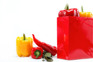 Healthy food. Fresh vegetables.Peppers in a red gift bag on a wh