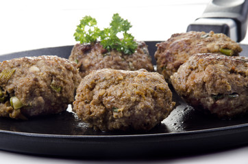 freshly fried meat balls lying on a pan