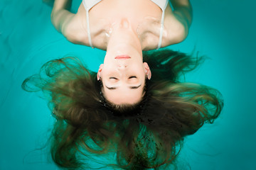 Wellness - junge Frau beim Floaten oder Schweben im Wasser
