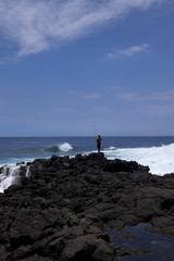 man fishing  in south point park on hawaii's  coast