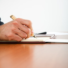 Businessman's hands while writing some documents