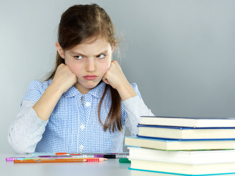 Cute little child is stressed out to do her homework