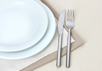 Table setting with fork, knife, plates, and napkin