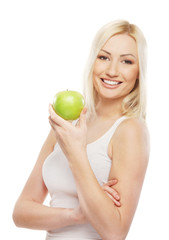 A young blond woman holding a fresh green apple