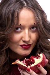 Portrait of young beautiful woman with pomegranates in her hands