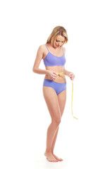 A young and fit woman with a measuring tape