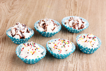Creamy cupcakes on wooden background