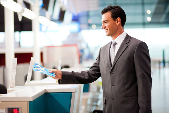 handsome businessman handing over air ticket at check in