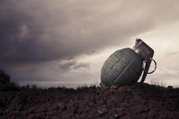 green grenade on a battlefield at dusk