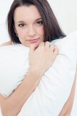 Close-up of an attractive young female holding a pillow