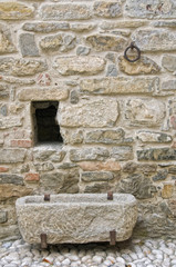 Stone wall detail with old stone watering place