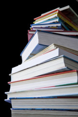 Pile of hard cover books isolated ion a black baground