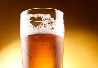 Glas bier met het hart vertegenwoordigd met schuim close-up ove