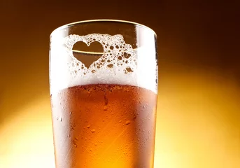 Fotobehang Glas bier met het hart vertegenwoordigd met schuim close-up ove © Hyrma