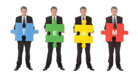 Fototapeta premium Group of business people holding jigsaw puzzle