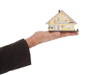 Businessman holding model of a house in hands