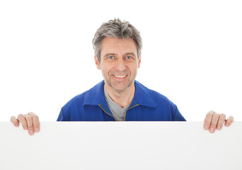 Portrait of automechanic holding empty banner