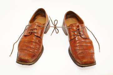 Pair of old male shoes with the connected laces
