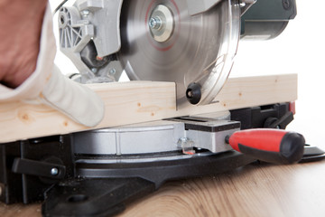 Worker cutting timber using circular saw