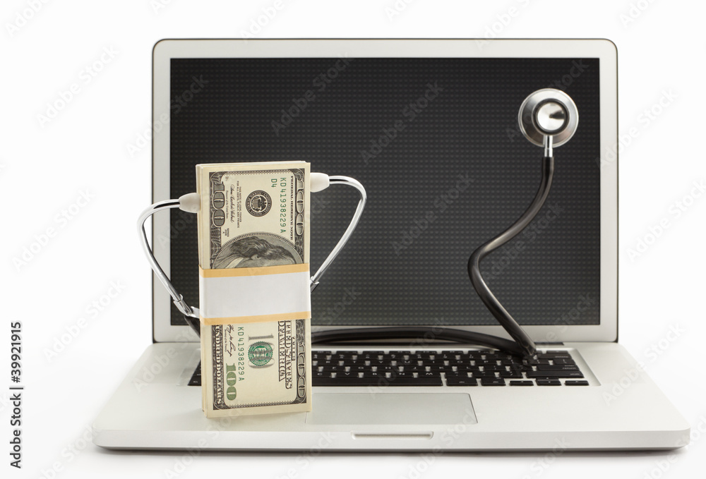 Wall mural stack of dollar bills with stethoscope on laptop